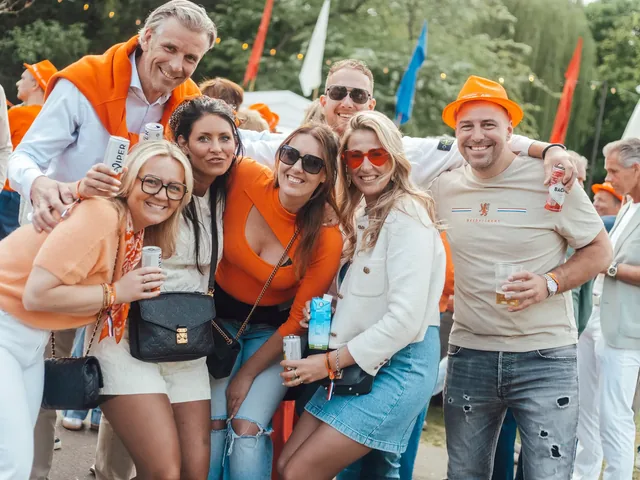 Een groep vrienden in het oranje en wit op het terrein